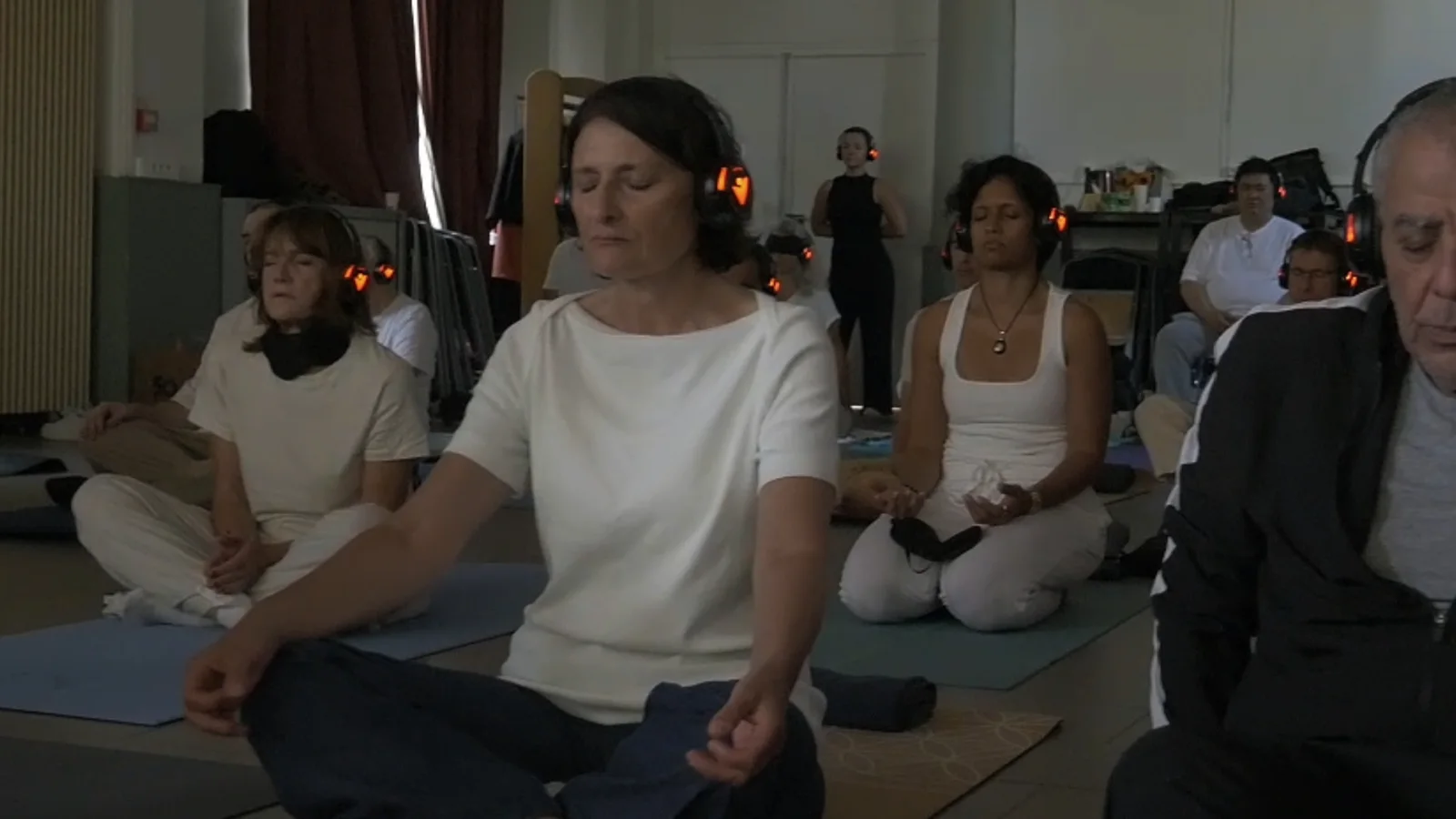 Méditation assise en groupe, avec des casques audio